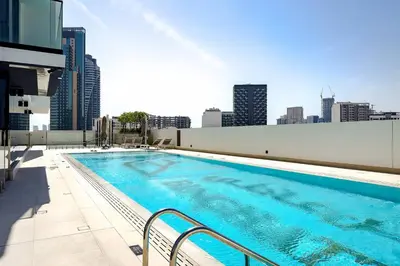 a large swimming pool on the roof of a building at Cozy 1BR apartment in Binghatti Venus JVC in Dubai