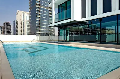 a large swimming pool in front of a building at Cozy 1BR apartment in Binghatti Venus JVC in Dubai