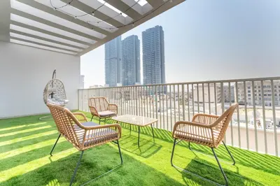 a room with chairs and a table on a balcony at New 1 BR with 2 Balconies Near Circle Mall, Luma22 West Tower, JVC By Deluxe Holiday Homes in Dubai