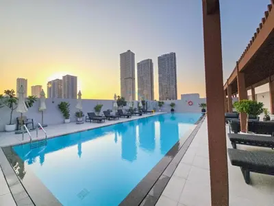 a large swimming pool on the roof of a building at New 1 BR with 2 Balconies Near Circle Mall, Luma22 West Tower, JVC By Deluxe Holiday Homes in Dubai