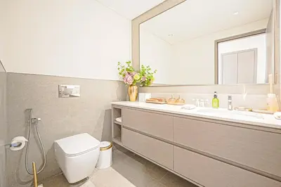a bathroom with a sink and a toilet and a mirror at Grande Signature Residences Luxury 3BR - Burj View in Dubai Downtown in Dubai