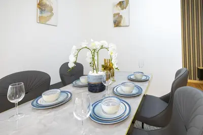 a dining table with blue and white plates and wine glasses at Near Beach Luxurious 2-Bedroom in JBR in Dubai