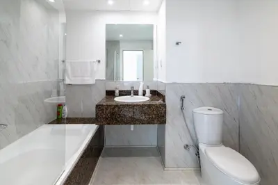 a bathroom with a tub and a sink and a toilet at Near Beach Luxurious 2-Bedroom in JBR in Dubai