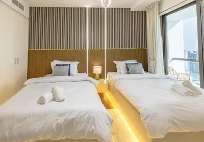 two beds in a room with a window at Near Beach Luxurious 2-Bedroom in JBR in Dubai