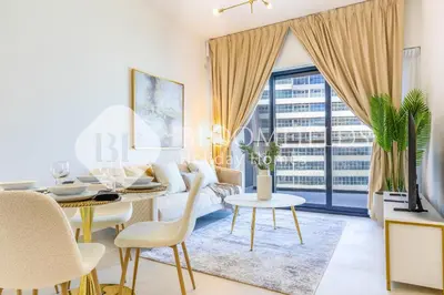 a living room with a table and chairs and a dining room at Bloomfields Cozy 1Br In Binghatti Creek in Dubai