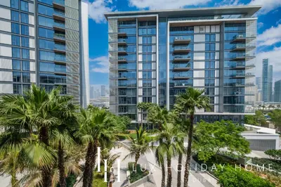 a tall building with palm trees in front of it at LUX The Bluewaters Island Suite 2 in Dubai
