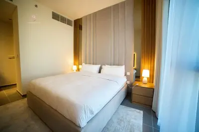 a bedroom with a large white bed and two lamps at Comfortable 2BR Stay with Sea View in Dubai