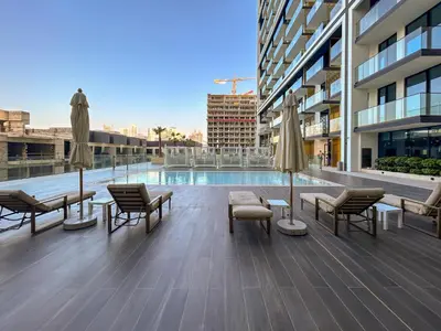 a patio with chairs and umbrellas and a pool at BLVD - Luxe Retreat - Stylish Stay with Full Privacy in Dubai