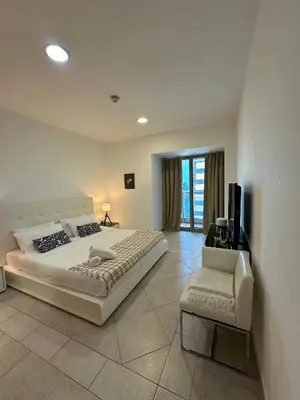a bedroom with a large bed and a chair at Prime Marina Location Stylish Apartment in Princess Tower in Dubai