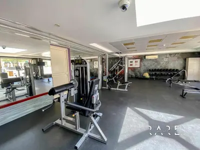 a gym with several treadmills and machines at Rare Holiday Homes - Near Metro Station - Greens - Al Arta - R215 in Dubai