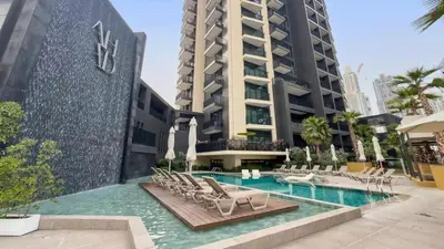 a swimming pool with chairs and a building at TRPS - Ahad Residences, Business Bay - 1BR Luxurious Apartment - Massive Balcony with Pool View in Dubai
