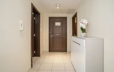 a hallway with a door and a vase of flowers on a counter at Granduer 1 BR in Windsor Manor Canal Front Living With Burj Views in Dubai