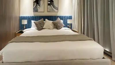 a bedroom with a large white bed with pillows at Bespoke Holiday Homes - Stylish 1BR Penthouse in The Autograph in Dubai