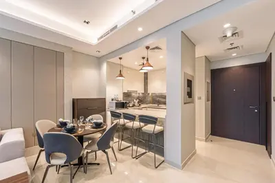 a dining room and kitchen with a table and chairs at Contemporary 1BR Prime Location with Parking in Dubai