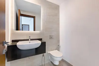 a bathroom with a sink and a toilet and a mirror at Celestial View 1BR apartment in JVC in Dubai