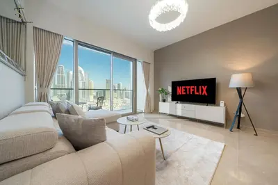 a living room with a couch and a tv at Burj Khalifa Luxurious 2BR Grande - Downtown in Dubai