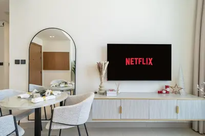 a living room with a tv on a wall at Modern JVC Apartment Views of Marina Skylines in Dubai