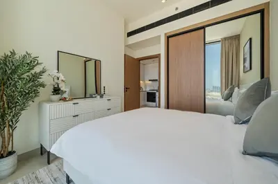 a bedroom with a white bed and a large mirror at Modern JVC Apartment Views of Marina Skylines in Dubai