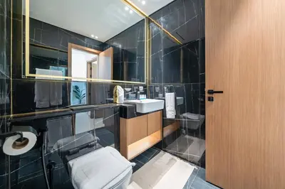 a bathroom with a toilet and a sink and a mirror at Modern JVC Apartment Views of Marina Skylines in Dubai