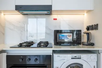a kitchen with a microwave and a washing machine at Modern JVC Apartment Views of Marina Skylines in Dubai