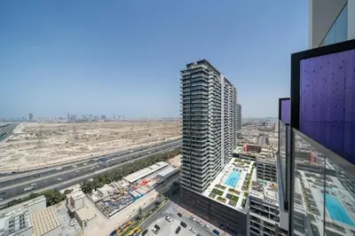 a view of a tall building in a city at Modern JVC Apartment Views of Marina Skylines in Dubai