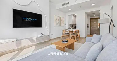 a living room with a couch and a table at Elegant Luxury 1BR - Modern Design - JVC in Dubai