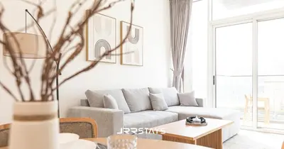 a living room with a couch and a table at Elegant Luxury 1BR - Modern Design - JVC in Dubai