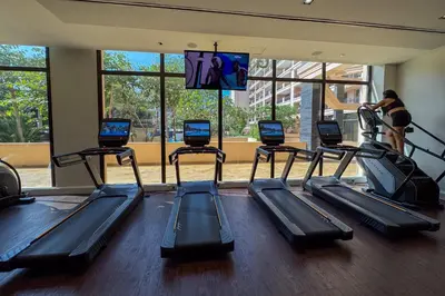 a gym with several treadmills in a room at Homely 1 Bedroom on Palm Jumeirah with private beach in Dubai