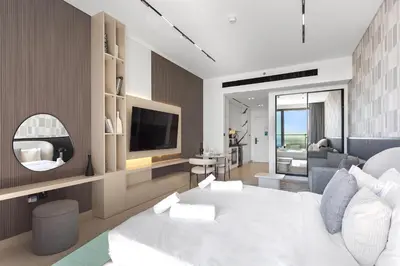 a bedroom with a white bed and a television at Stylish Studio with Jacuzzi in Business Bay in Dubai