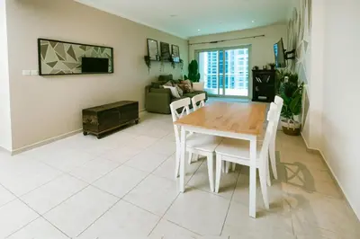 a living room with a wooden table and chairs at Marina Mirage in Dubai