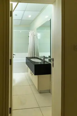 a bathroom with a sink and a mirror and a tub at Marina Mirage in Dubai