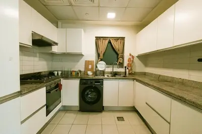 a kitchen with a washing machine in the middle at Marina Mirage in Dubai