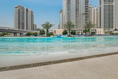 a swimming pool in a city with tall buildings at qua Serenity Poolside with Community Views in Dubai