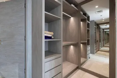 a walk in closet with wooden cabinets and shelves at Luxe 1BR Burj View 10 min Walk to Dubai Mall in Dubai
