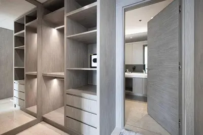 a walk in closet with wooden shelves and a kitchen at Luxe 1BR Burj View 10 min Walk to Dubai Mall in Dubai