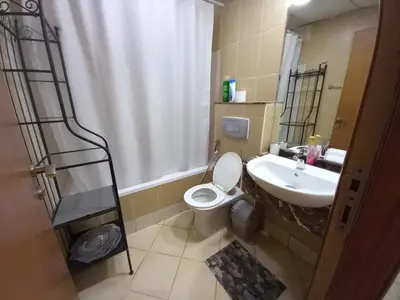 a bathroom with a white toilet and a sink at Diamond Studio Marina in Dubai