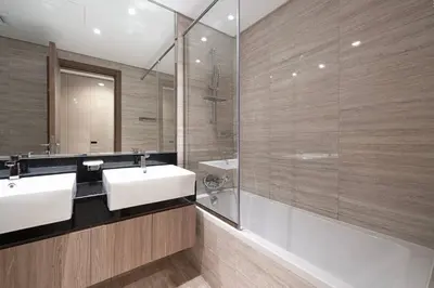 a bathroom with two sinks and a glass shower at Mahogany 10 - 2BR 8 PAX - Infinity Pool & Modern in Dubai