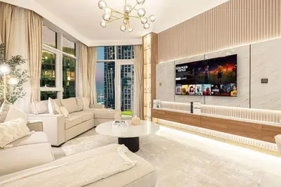 a living room with a couch and a tv at Mahogany 10 - 2BR 8 PAX - Infinity Pool & Modern in Dubai