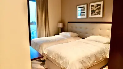 a hotel room with two beds and a window at The Address Fountain Views Residence High Floor with Burj Khalifa view and access to Dubai mall in Dubai
