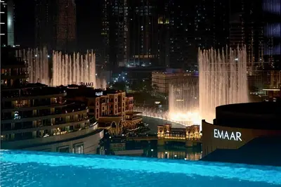 a view of a city at night with a fountain at The Address Fountain Views Residence High Floor with Burj Khalifa view and access to Dubai mall in Dubai