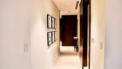 a hallway with three pictures on the wall and a door at The Address Fountain Views Residence High Floor with Burj Khalifa view and access to Dubai mall in Dubai