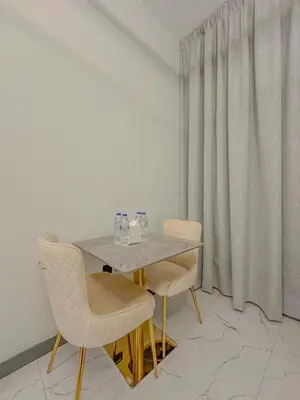 a dining table and two chairs in a room at Studio Apartment in Rukan Wadi Al Safa by the S Holiday Homes in Dubai