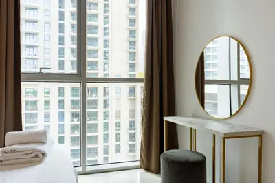 a bedroom with a mirror and a table and a window at TRPS - Beach Isle Tower 1, Dubai Harbour - 1BR Premium Beachfront - Private Beach Access in Dubai