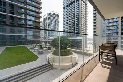 a balcony with a view of a garden and buildings at TRPS - Beach Isle Tower 1, Dubai Harbour - 1BR Premium Beachfront - Private Beach Access in Dubai