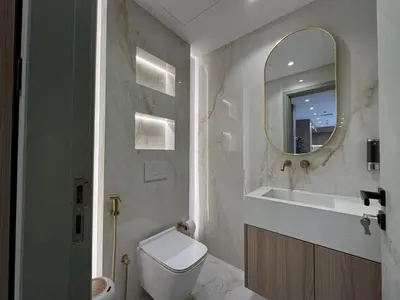 a bathroom with a toilet and a sink and a mirror at A unique luxury touch in JLT in Dubai