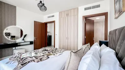 a bedroom with a white bed and a mirror at Trophy-Lux Villa w Big Garden & BBQ Grill in Dubai
