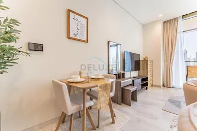 a dining room with a table and a tv at Luxury Studio Steps from Dubai Canal and Minutes to Burj Khalifa, Peninsula Five - 3, Business Bay By Deluxe Holiday Homes in Dubai