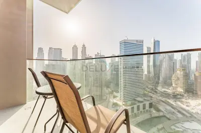 a balcony with two chairs and a view of the city at Luxury Studio Steps from Dubai Canal and Minutes to Burj Khalifa, Peninsula Five - 3, Business Bay By Deluxe Holiday Homes in Dubai