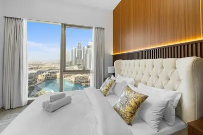 a bedroom with a large white bed with a large window at Luxury Stay Just Steps from Dubai Mall 2BR Grande in Dubai
