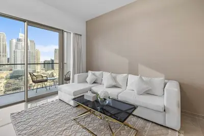 a living room with a white couch and a glass table at Luxury Stay Just Steps from Dubai Mall 2BR Grande in Dubai